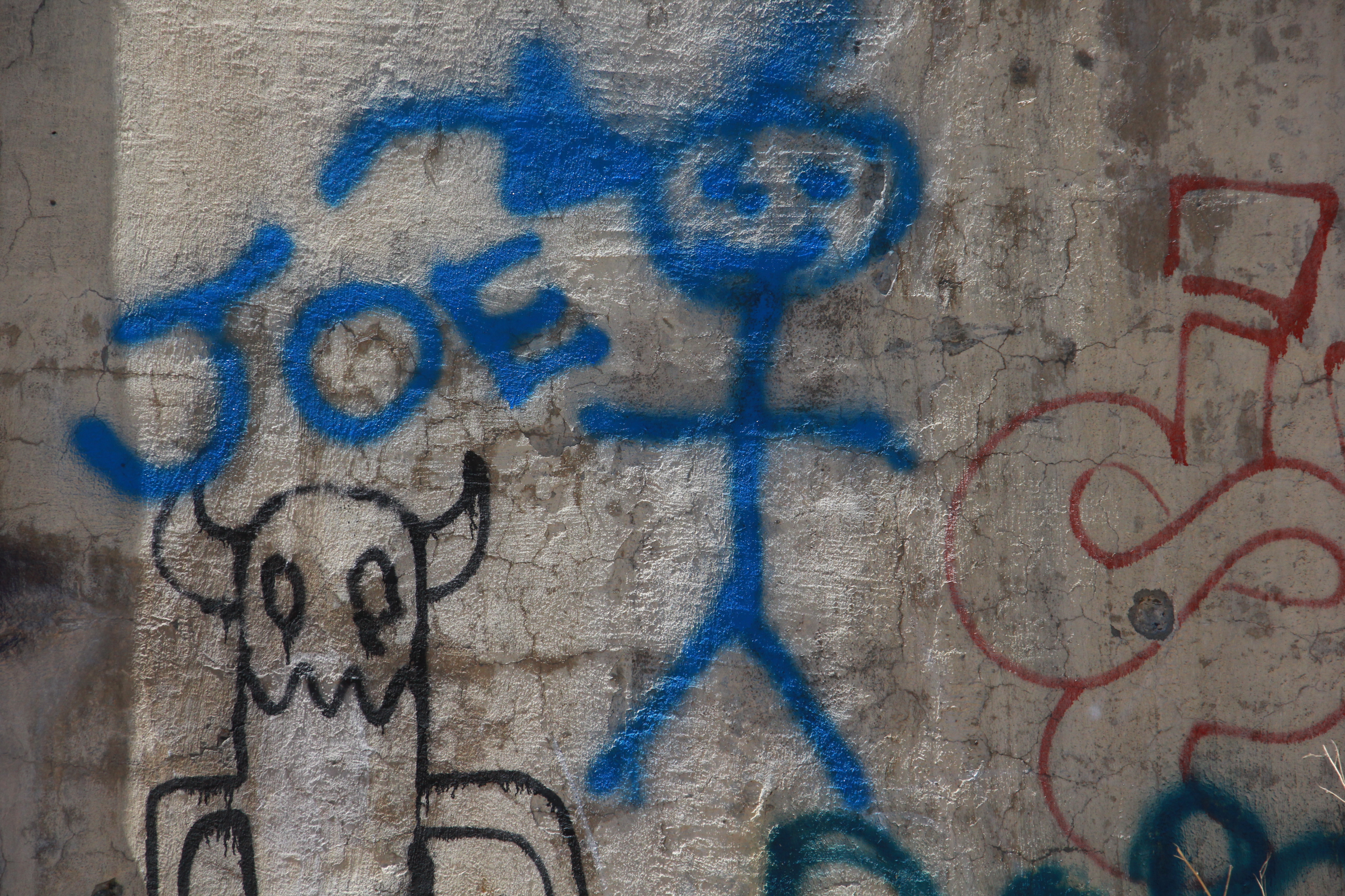 Spray Paint Graffiti Figure In Blue On Wall