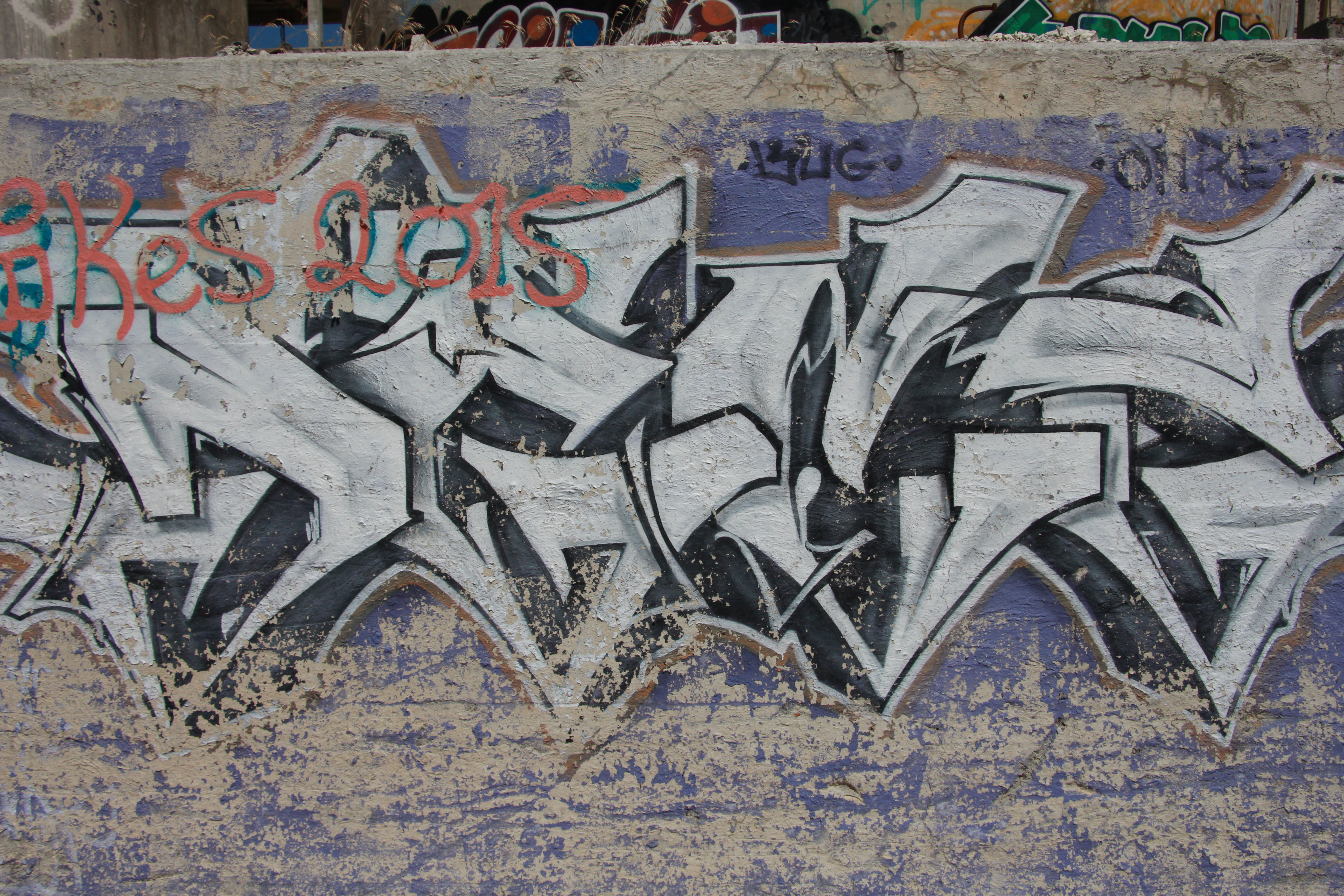 White And Blue Spray Paint Graffiti On Wall